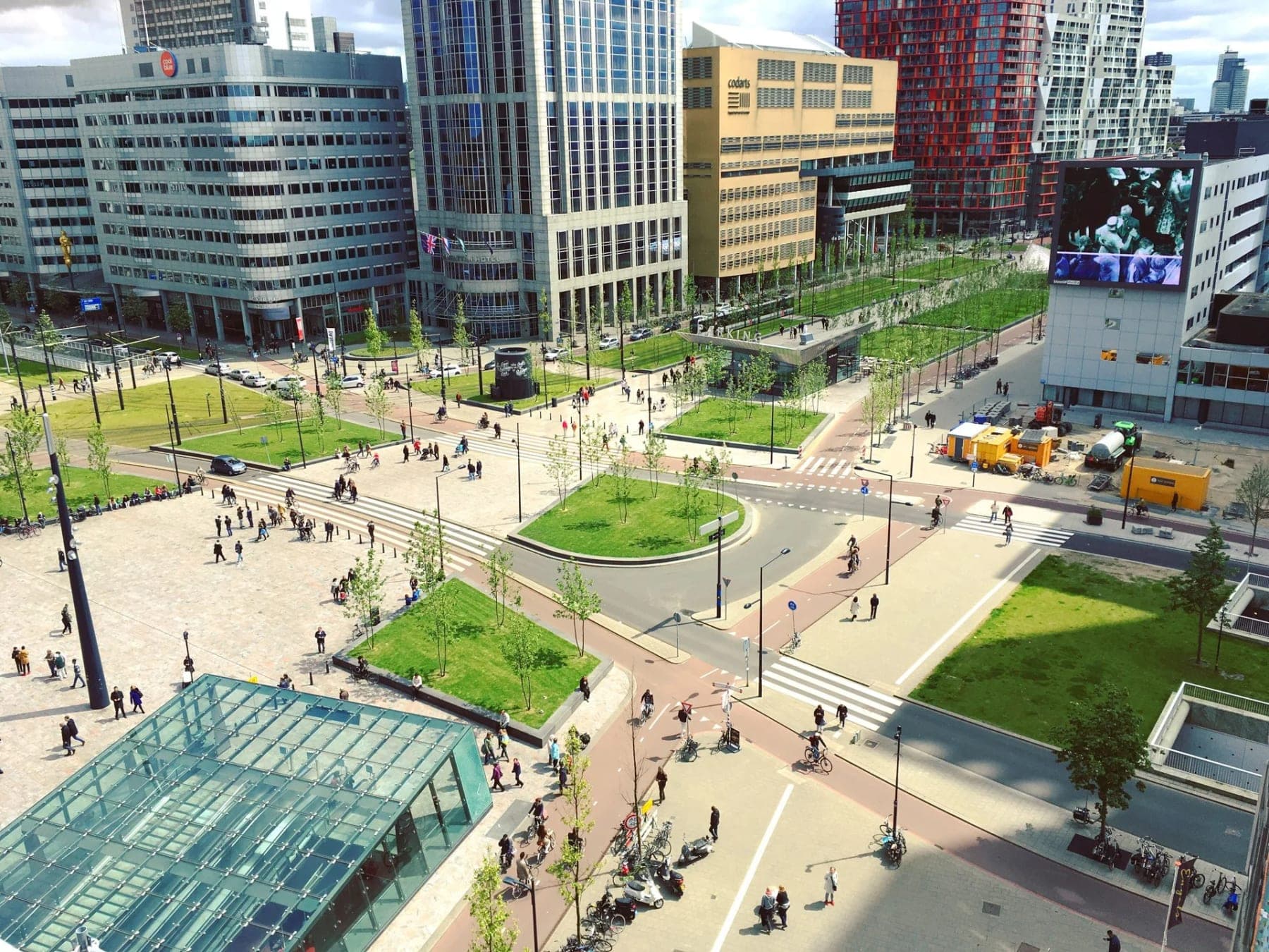 Stadsplein van bovenaf met wandelaars en bomen